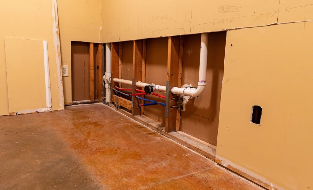 PEX and PVC supply lines running through open wall studs during a remodel
