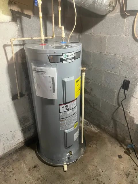 After: New A. O. Smith ProLine electric water heater on a drain pan in the same basement corner