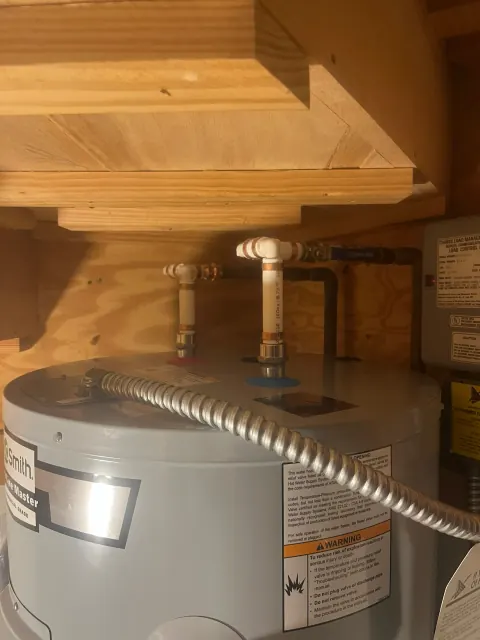 After: Top of the new A. O. Smith water heater with reworked supply lines under the same wooden shelf