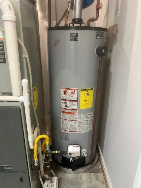 Before: Kenmore gas water heater with a yellow gas line and flue pipe next to a furnace