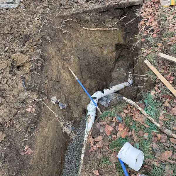 New PVC sewer pipe installed in the excavation.