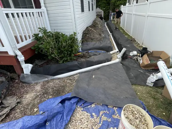 During: Gravel bedding poured around the new sewer pipe in the side yard.