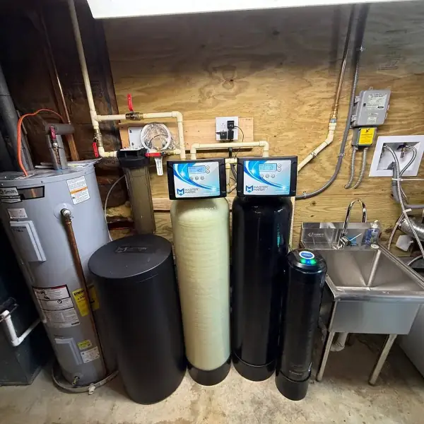 Water heater installed beside a two-tank softener and filter system.