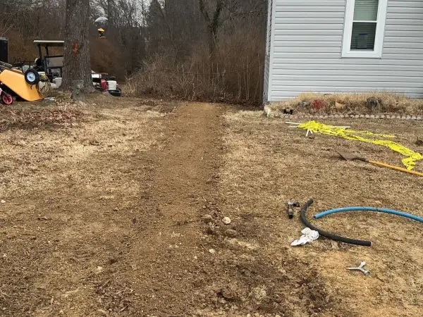 Before: Water service trench with blue pipe near the house.