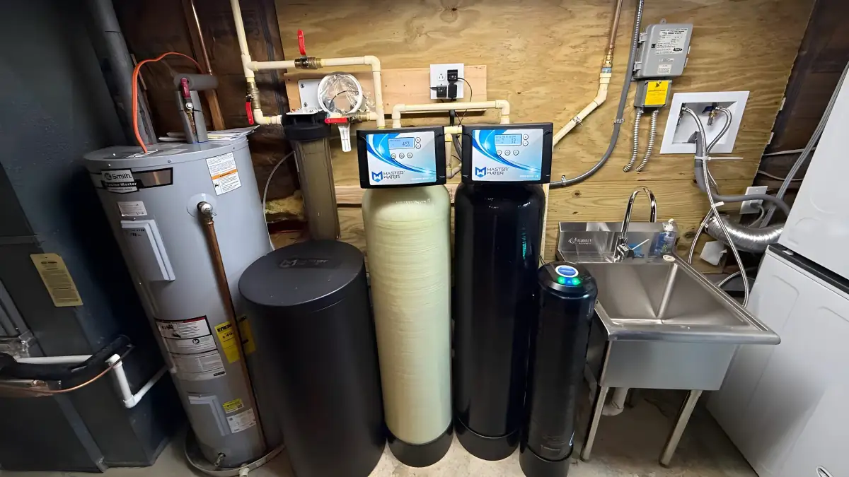 Water heater installed beside a two-tank softener and filter system.