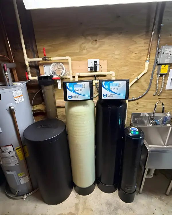 Water heater installed beside a two-tank softener and filter system.